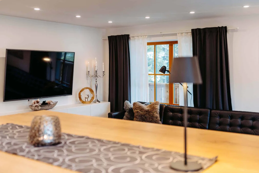 Gemütliches Wohnzimmer im Silberleithen Estate mit modernen Möbeln und Blick auf die Berge, ideal für einen entspannten Urlaub an der Zugspitze.